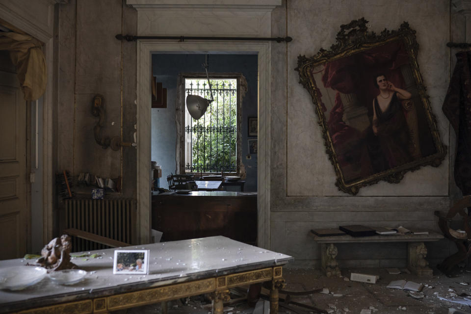 A crooked paint hangs on the wall of the Sursock Palace, heavily damaged after the explosion in the seaport of Beirut, Lebanon, Friday, Aug. 7, 2020. The 150-year-old palace withstood two world wars, the fall of the Ottoman empire, the French mandate and Lebanese independence. After the country's 1975-1990 civil war, it took 20 years of careful restoration for the family to bring the palace back to its former glory. (AP Photo/Felipe Dana)