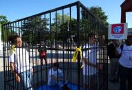 Teenagers are pictured in a cage during a demonstration to condemn the US President Trump administrationÕs policy of child detention in Geneva