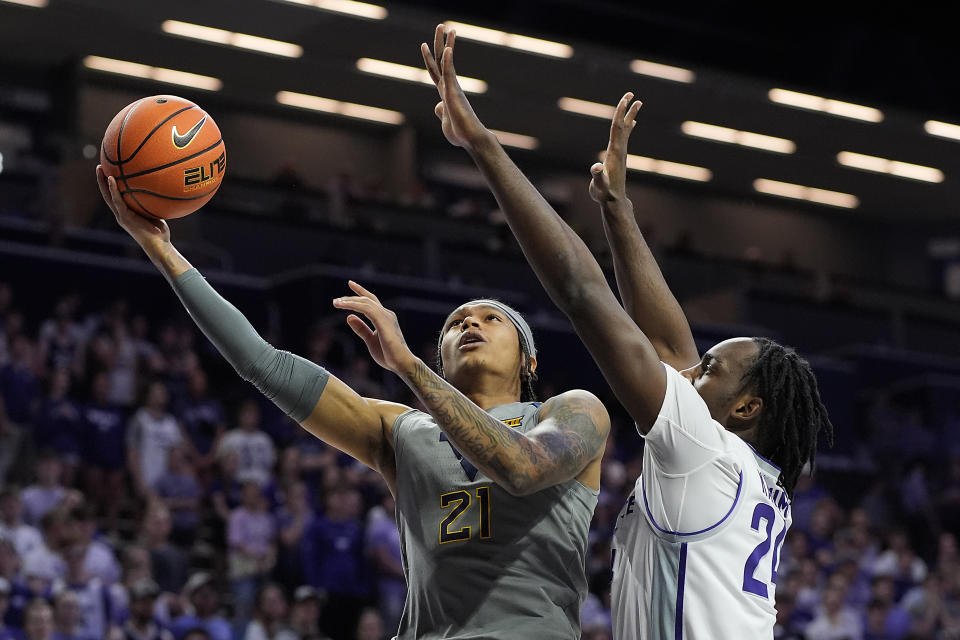 West Virginia guard RaeQuan Battle (21) shoots under pressure from Kansas State forward Arthur Kaluma (24) during the first half of an NCAA college basketball game Monday, Feb. 26, 2024, in Manhattan, Kan. (AP Photo/Charlie Riedel)