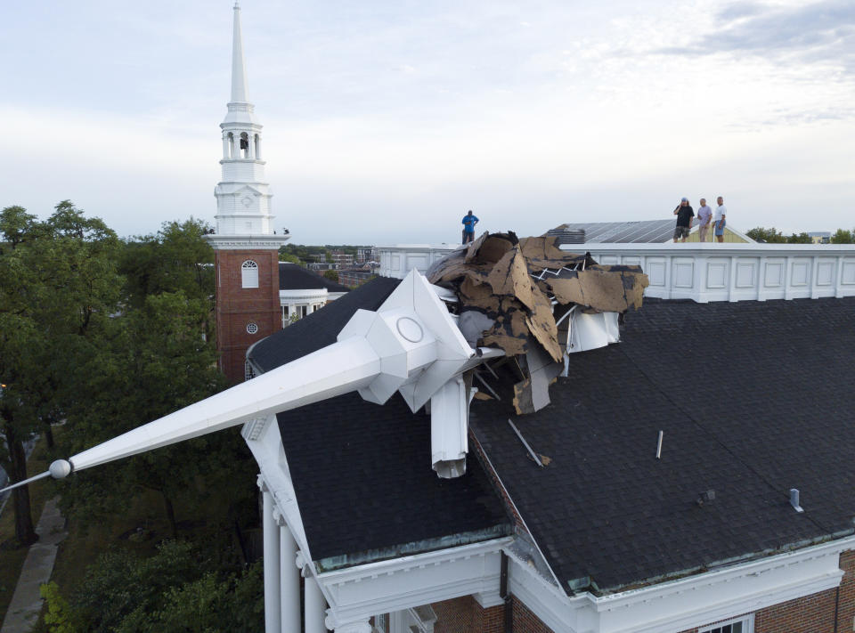 The steeple at College Church in Wheaton, Ill. was toppled during a storm Monday, Aug. 10, 2020, in the northwest suburbs of Chicago, Ill. Church officials check out the damage from the rooftop which also left several trees in the nearby park heavily damaged. (Mark Welsh /Daily Herald via AP)