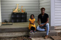 Stefan Powdrill, 19, right, sits with his 6-year-old sister, Kahea Street, on the front porch of their home in Arlington, Texas, Sunday, Oct. 24, 2021. Powdrill, who is working to become a firefighter for the city, also has been active in local politics and has spoken at hearings about his opposition to adding more natural gas wells in the city. His family's home is near two of many well sites in the city, which sits atop what is known as the Barnett Shale, one of the geological formations that is a rich source of natural gas that's used in this country and, increasingly, shipped overseas. (AP Photo/Martha Irvine)