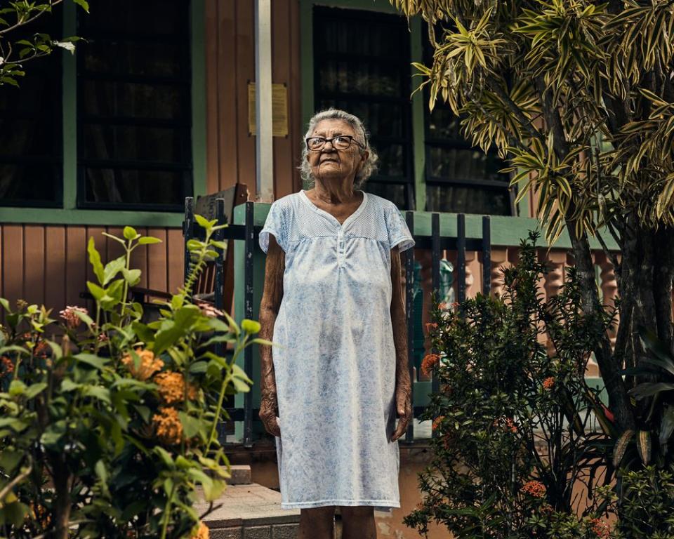 Magdalena Flores poses in front of her home in Utuado on Aug. 31. Her daughter, Maribel, died in the aftermath of the storm from asthma complications.