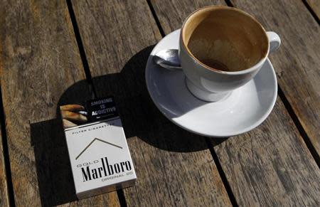 A Marlboro cigarettes pack, a brand of Philip Morris Tobacco, lies next to an empty coffee cup at a cafe in central Sydney June 27, 2011. REUTERS/Daniel Munoz