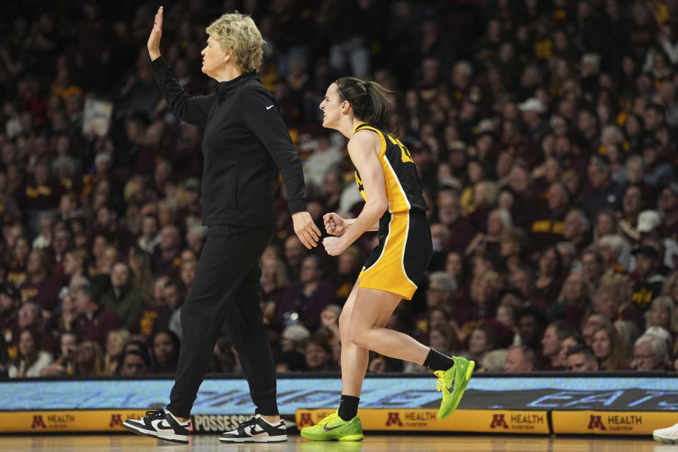 Iowa guard Caitlin Clark, right, celebrates next to coach Lisa Bluder after an Iowa basket against Minnesota during the first half of an NCAA college basketball game Wednesday, Feb. 28, 2024, in Minneapolis. (AP Photo/Abbie Parr)