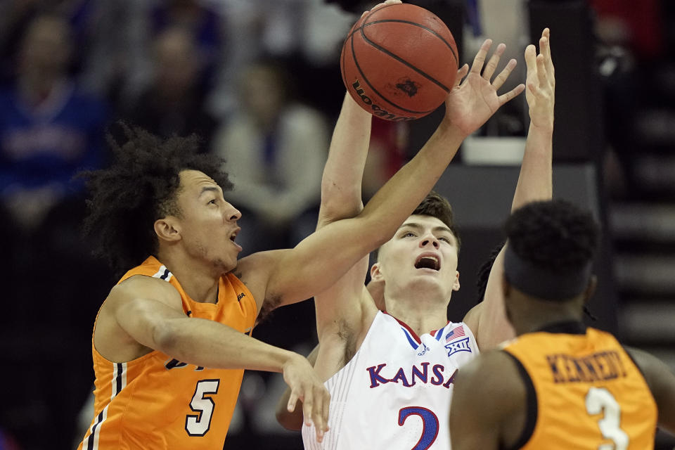 Kansas' Christian Braun, center, shoots under pressure from UTEP's Emmanuel White (5) and Keonte Kennedy (3) during the first half of an NCAA college basketball game Tuesday, Dec. 7, 2021, in Kansas City, Mo. (AP Photo/Charlie Riedel)