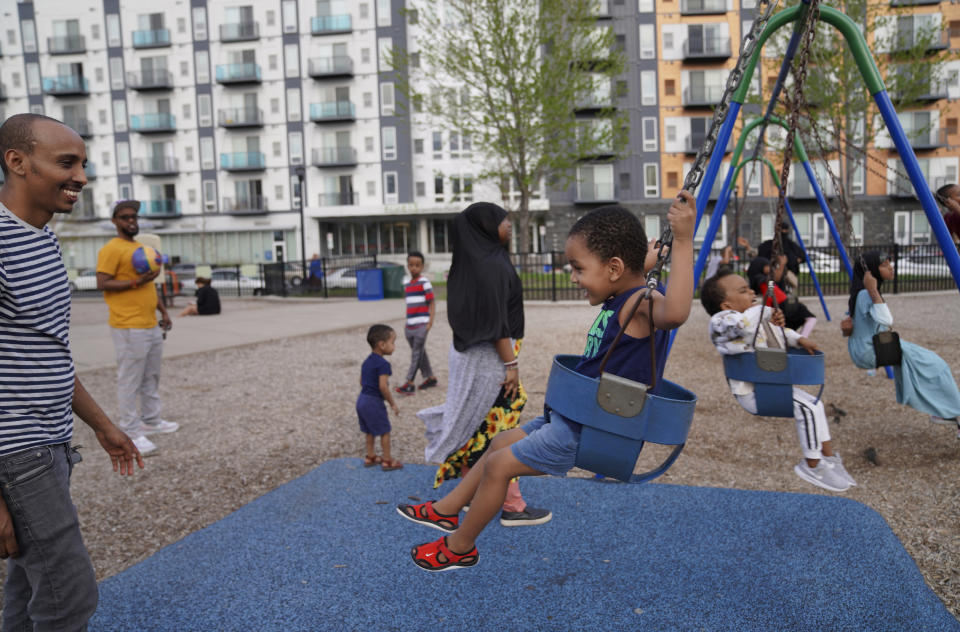 Roba Aliye, left, pushes a boy in a swing at a park in the predominantly Somali neighborhood of Cedar-Riverside in Minneapolis on Thursday, May 12, 2022. (AP Photo/Jessie Wardarski)