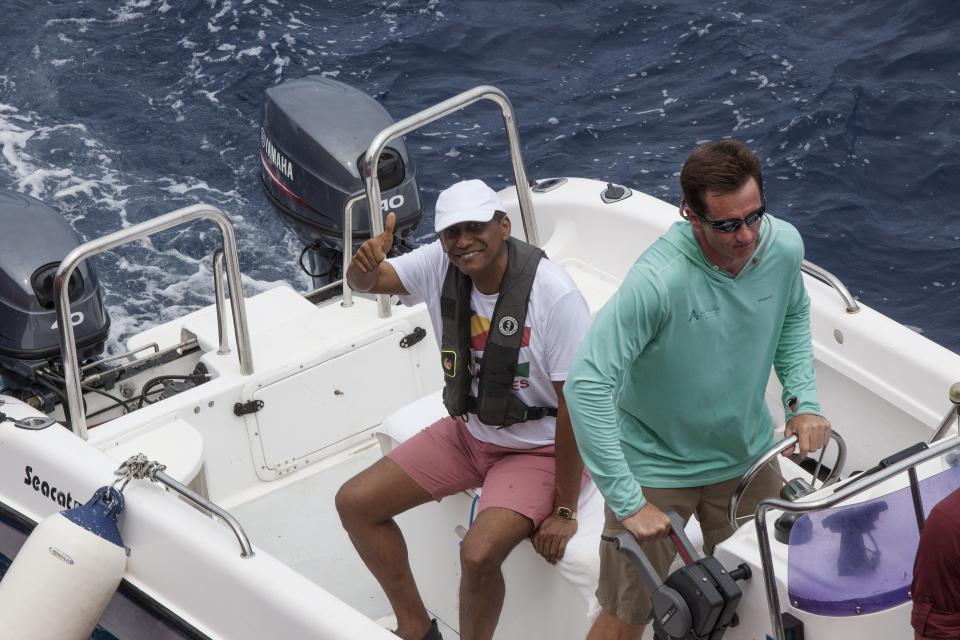 Seychelles President Danny Faure waves as returns from a submersible dive, off the coast of Seychelles on Sunday April 14, 2019. In a striking speech delivered from deep below the ocean's surface, the Seychelles president on Sunday made a global plea for stronger protection of the "beating blue heart of our planet." President Danny Faure's call for action, the first-ever live speech from an underwater submersible, came from one of the many island nations threatened by global warming.(AP Photo/Steve Barker)