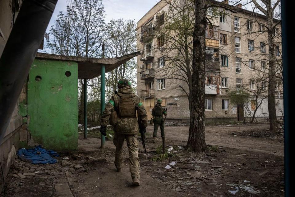 Soldiers of Ukraine's 93rd Brigade run between buildings in Bahkmut, Donetsk Oblast, on April 18, 2023. (Ed Ram/The Washington Post via Getty Images)