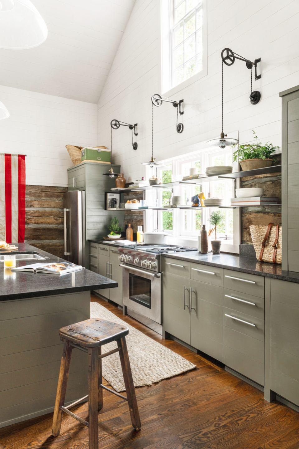 olive green cabinets in a kitchen with honed black granite countertops and lots of windows
