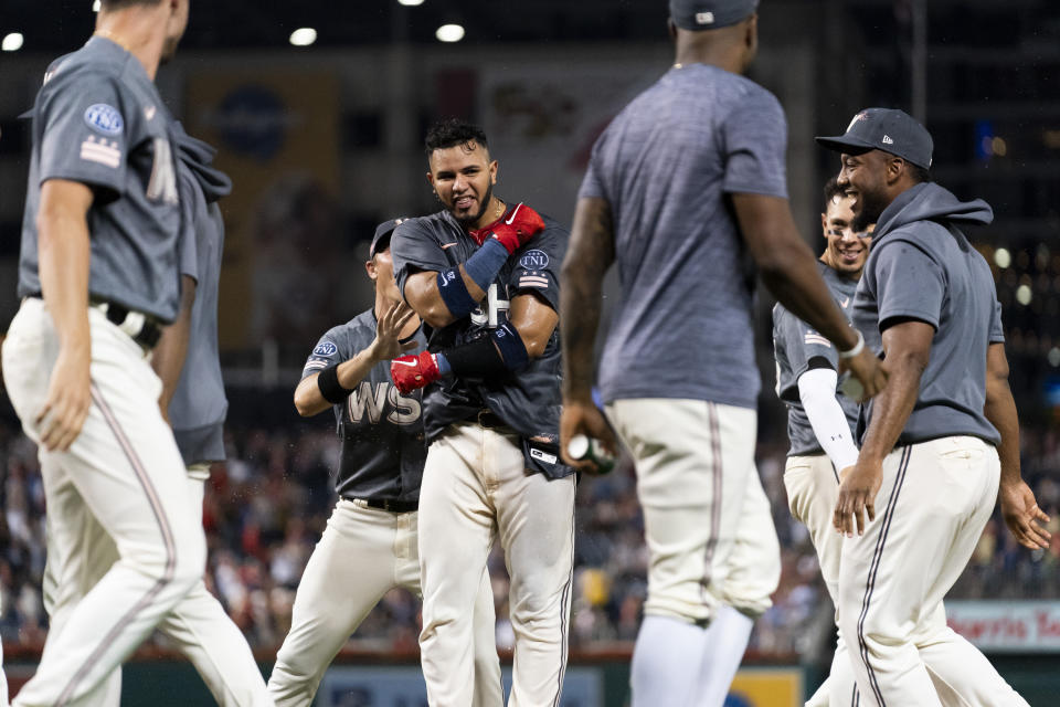 Washington Nationals' Keibert Ruiz, center, celebrates after hitting a walkoff home run during the ninth inning of a baseball game against the Oakland Athletics, Saturday, Aug. 12, 2023, in Washington. (AP Photo/Stephanie Scarbrough)