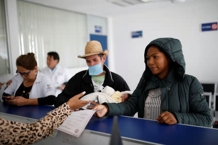 Honduran migrants Erly Marcial, 21, and Alvin Reyes, 39, receive the Mexican birth certificate for their newborn son Alvin, in Puebla, Mexico, November 13, 2018. REUTERS/Carlos Garcia Rawlins