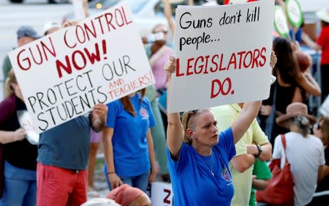 Stefanie Hartman of Coconut Creek, Florida, holds a sign during the March for Action on Gun Violence in Broward County in Fort Lauderdale - Credit: Reuters