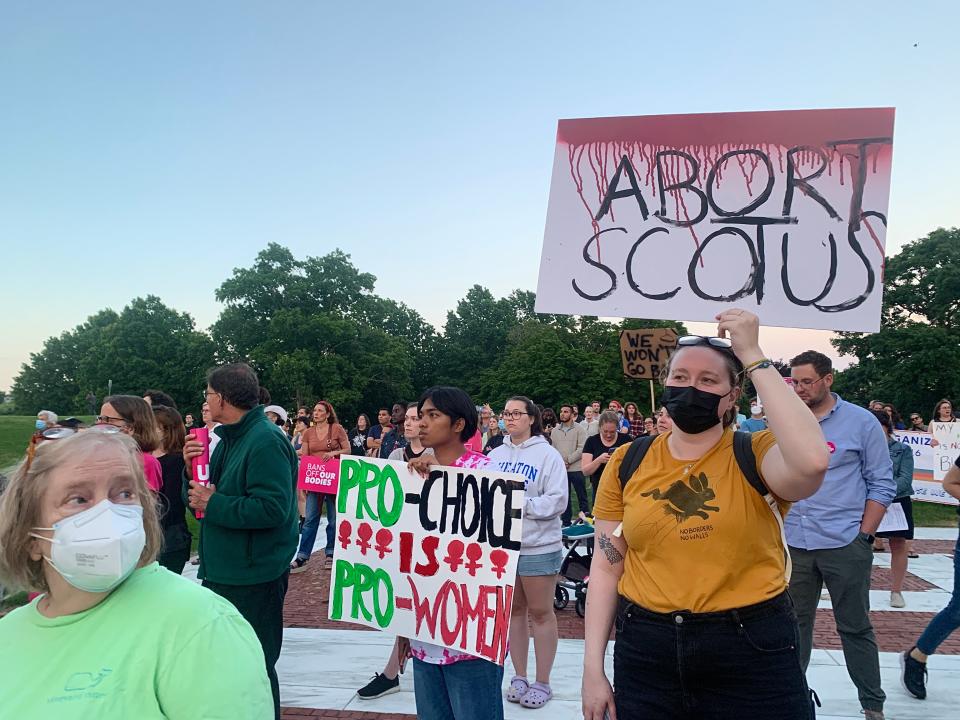 Demonstrators hold homemade signs decrying the Supreme Court decision.