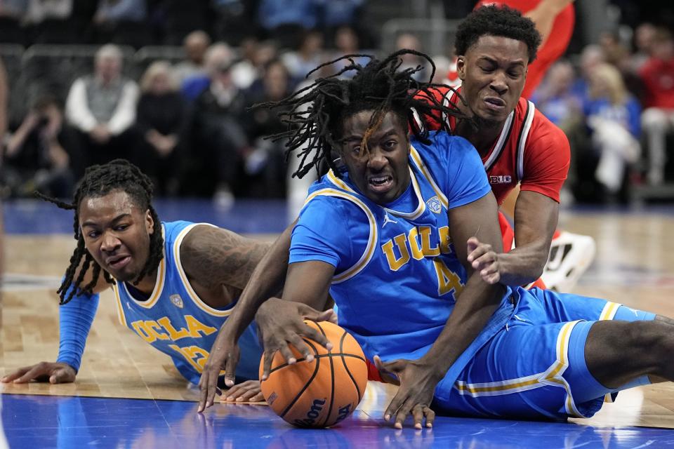 UCLA guard Sebastian Mack (12) UCLA guard Will McClendon (4) and Ohio State guard Dale Bonner (4) dive for the ball during the first half of an NCAA college basketball game Saturday, Dec. 16, 2023, in Atlanta, Ga. | Brynn Anderson, Associated Press