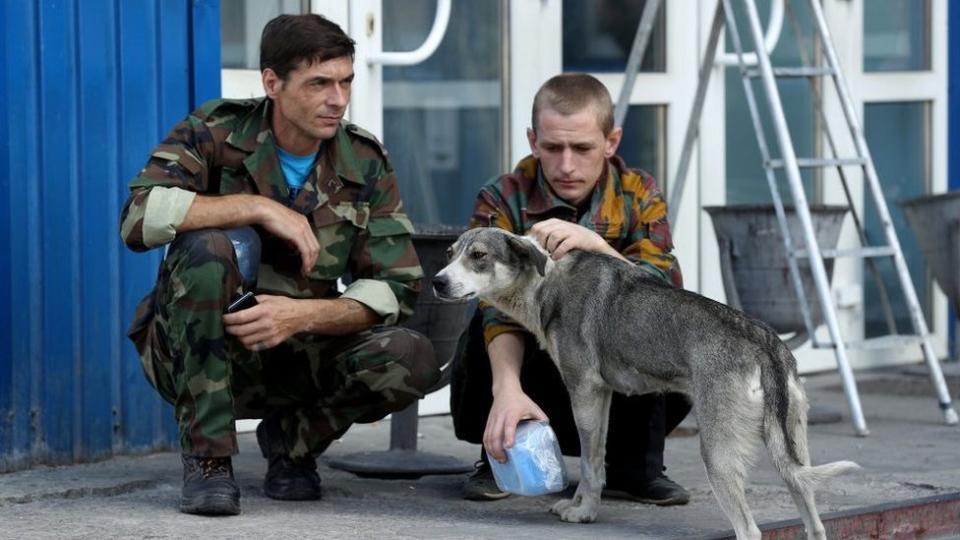 Guardias de Chernóbil con un perro callejero en 2017.