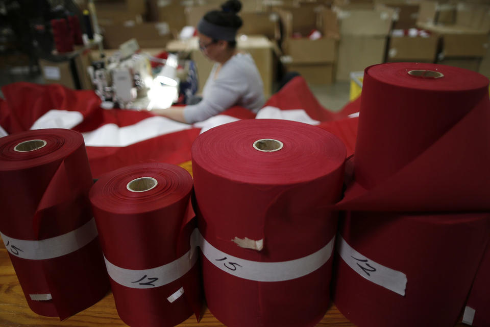 <p>Rolls of red fabric sit as a worker sews an American flag at the FlagSource facility in Batavia, Illinois, U.S., on Tuesday, June 27, 2017. (Photo: Jim Young/Bloomberg via Getty Images) </p>