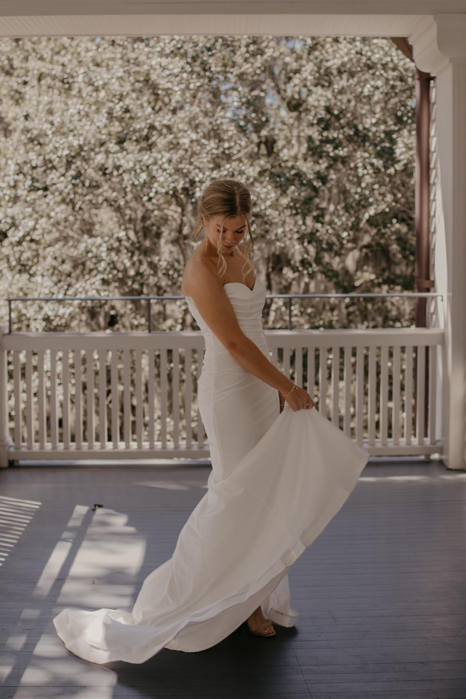 A bride spins in her wedding dress on a porch.