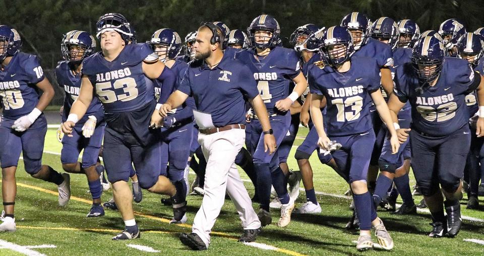 Dylan Clark leads the Alonso High football team onto the field during a 2021 game. Thursday, Clark was named the head football coach at Parrish Community High School.