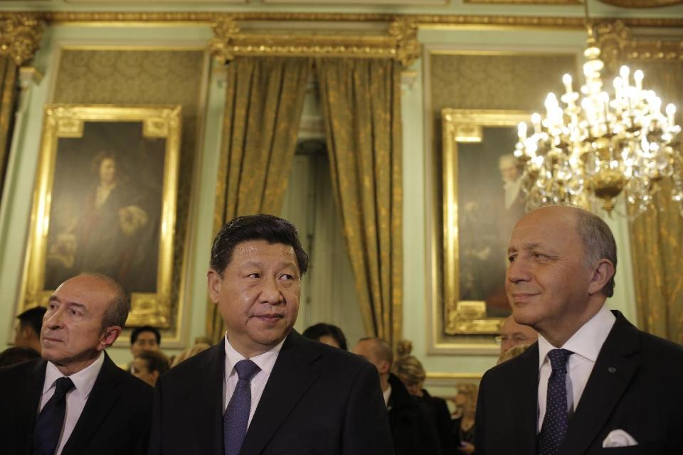 Chinese President Xi Jinping, center, Lyon's mayor Gerard Collomb, left, and French foreign minister Laurent Fabius, right, look on before a dinner at Lyon townhall, central France, Tuesday, March 25, 2014. Xi Jinping arrived in France for a three-day state visit. (AP Photo/Laurent Cipriani, Pool)