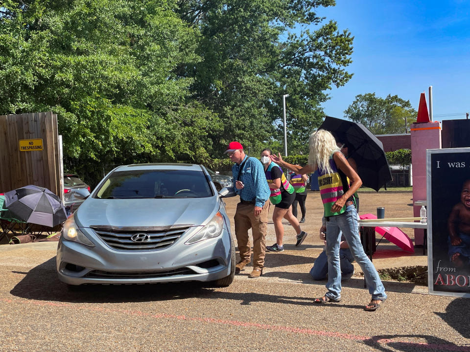 Patients rush past protesters leaving the Pink House after the U.S. Supreme Court ruled in the Dobbs v. Women's Health Organization abortion case. 