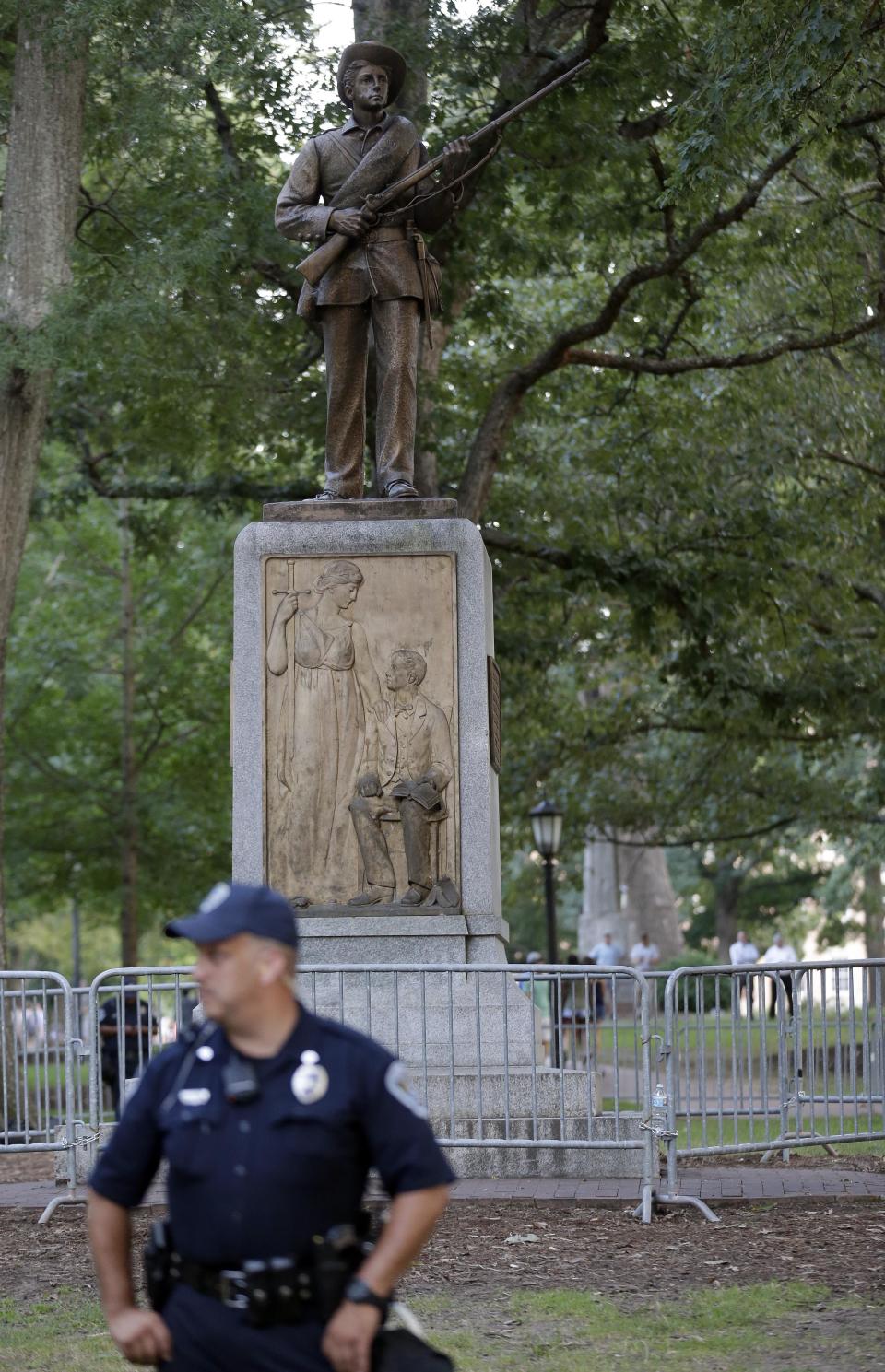 FILE - In this Aug. 22, 2017, file photo, police stand by a Confederate monument nicknamed "Silent Sam" at the University of North Carolina-Chapel Hill in Chapel Hill, N.C. University of North Carolina-Chapel Hill Chancellor Carol Folt says the school will remove the pedestal where the statue stood until protesters tore it down. Folt also announced to the campus Monday, Jan. 14, 2019, that she will step down at the end of the school year. (AP Photo/Gerry Broome, File)