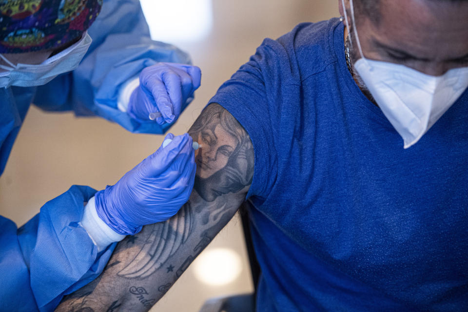 Javier Crespo receives a dose of the AstraZeneca COVID-19 vaccine, during a mass vaccination campaign at San Pedro Hospital, in Logrono, northern Spain, Wednesday, March 24, 2021. Spain resumed the use of the AstraZeneca vaccine on Wednesday. (AP Photo/Alvaro Barrientos)