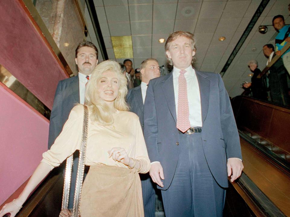 Marla Maples and donald trump go down an escalator