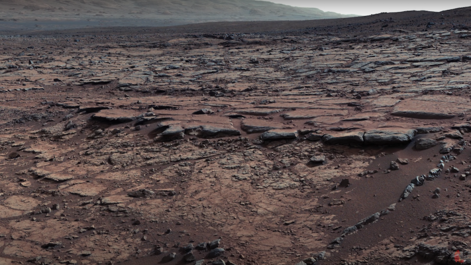 A shot of the barren, dusty surface of Mars.