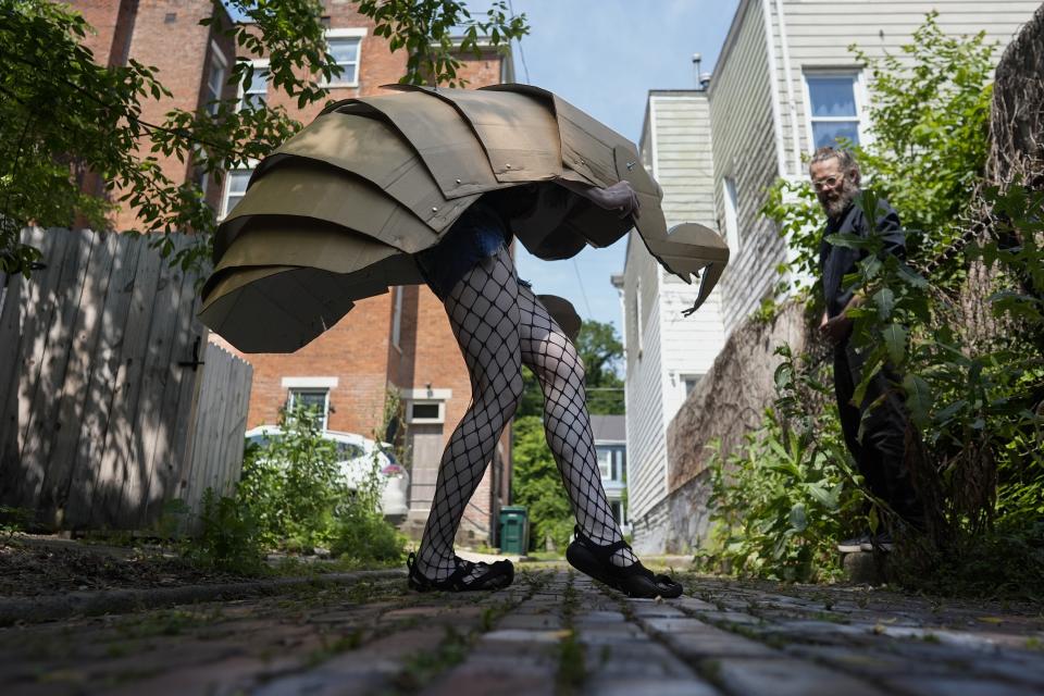 Renee Martin performs her cicada striptease in fishnet stockings and a cicada nymph puppet costume in a Cincinnati ally on Tuesday, June 4, 2024. The periodical cicadas that have blanketed parts of the American Midwest this spring are strange creatures, but they have nothing on some of their superfans. (AP Photo/Carolyn Kaster)