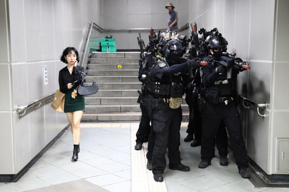 a woman walking by military troops