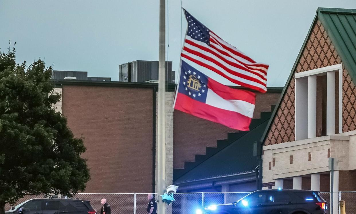 <span>The US and Georgia flags at half mast outside Apalachee high school a day after two students and two teachers were killed.</span><span>Photograph: John Spink/TNS/Zuma/Rex/Shutterstock</span>