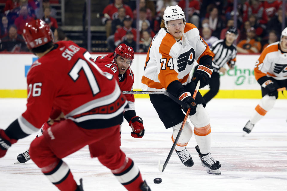 Philadelphia Flyers' Owen Tippett (74) battles with Carolina Hurricanes' Jordan Martinook (48) for the puck during the first period of an NHL hockey game in Raleigh, N.C., Thursday, March 9, 2023. (AP Photo/Karl B DeBlaker)