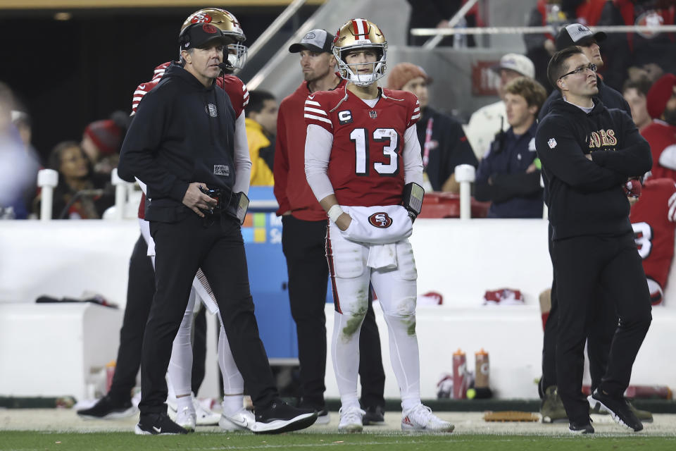 San Francisco 49ers quarterback Brock Purdy (13) stands on the sideline next to quarterbacks coach Brian Griese, left, during the second half of an NFL football game against the Baltimore Ravens in Santa Clara, Calif., Monday, Dec. 25, 2023. (AP Photo/Jed Jacobsohn)