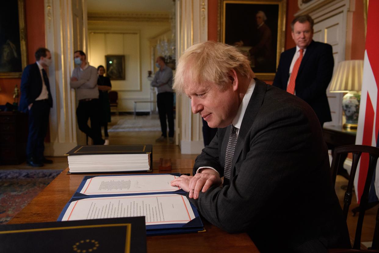 Britain's Prime Minister Boris Johnson poses for photographs after signing the Trade and Cooperation Agreement between the UK and the EU, the Brexit trade deal, at 10 Downing Street in central London on December 30, 2020. - British Prime Minister Boris Johnson on Wednesday signed a post-Brexit trade deal with the European Union, acclaiming it as the start of a "wonderful relationship" across the Channel. "It's an excellent deal for this country but also for our friends and partners," he said at the signing in Downing Street, after EU chiefs Ursula von der Leyen and Charles Michel earlier had themselves inked the 1,246-page Trade and Cooperation Agreement. (Photo by Leon Neal / POOL / AFP) (Photo by LEON NEAL/POOL/AFP via Getty Images)