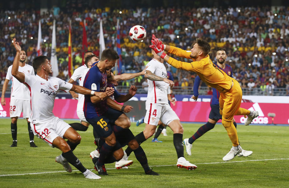 Sevilla goalkeeper Tomas Vaclik, right, leaps for a save during the Spanish Super Cup soccer match between Sevilla and Barcelona in Tangier, Morocco, Sunday, Aug. 12, 2018. (AP Photo/Mosa'ab Elshamy)