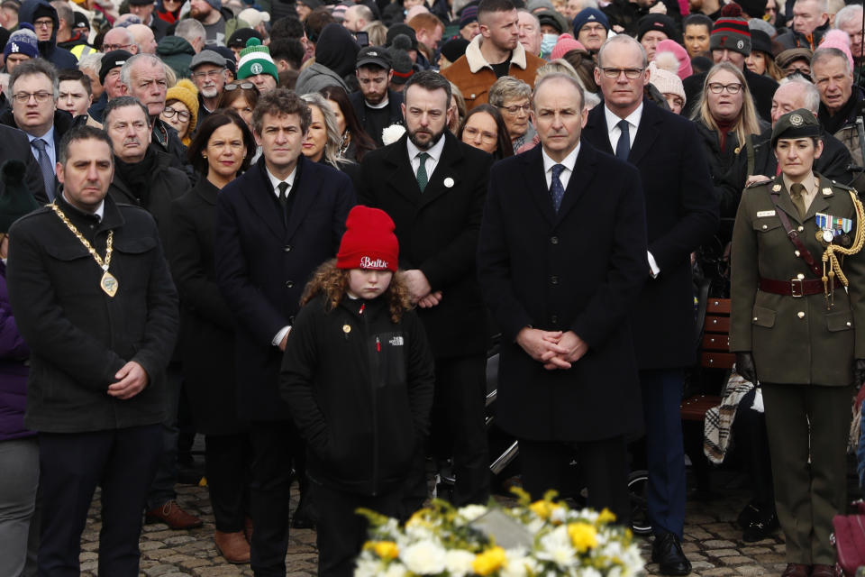 The Irish Prime Minister Micheal Martin, front right, pays his respects to the victims of Bloody Sunday during a march to commemorate the 50th anniversary of the 'Bloody Sunday' shootings in Londonderry, Sunday, Jan. 30, 2022. In 1972 British soldiers shot 28 unarmed civilians at a civil rights march, killing 13 on what is known as Bloody Sunday or the Bogside Massacre. Sunday marks the 50th anniversary of the shootings in the Bogside area of Londonderry .(AP Photo/Peter Morrison)