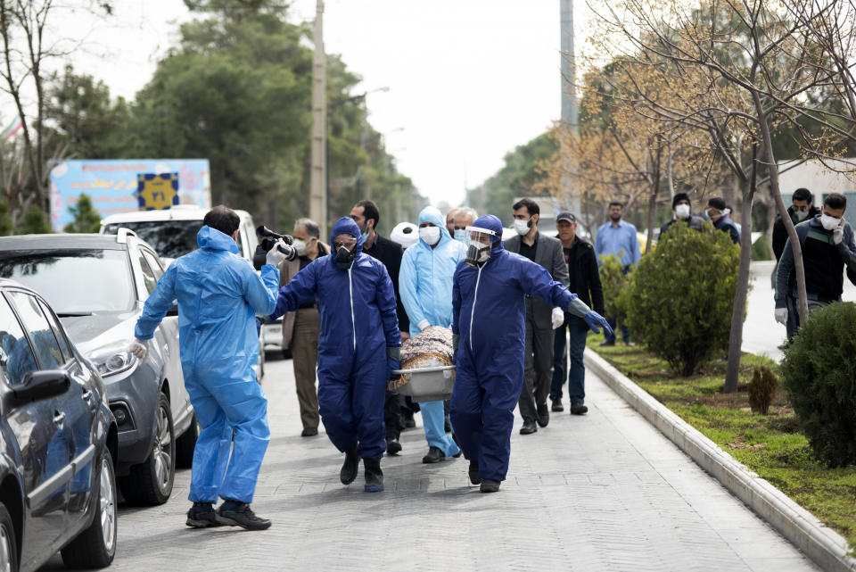 Men wearing protective gear carry the body of Fatemeh Rahbar, a lawmaker-elect from a Tehran constituency, who died on Saturday after being infected with the new coronavirus, at Behesht-e-Zahra cemetery, just outside Tehran, Iran, Sunday, March 8, 2020. Rahbar previously served three terms as lawmaker. With the approaching Persian New Year, known as Nowruz, officials kept up pressure on people not to travel and to stay home. Health Ministry spokesman Kianoush Jahanpour, who gave Iran's new casualty figures Sunday, reiterated that people should not even attend funerals. (Mehdi Khanlari/Fars News Agency via AP)