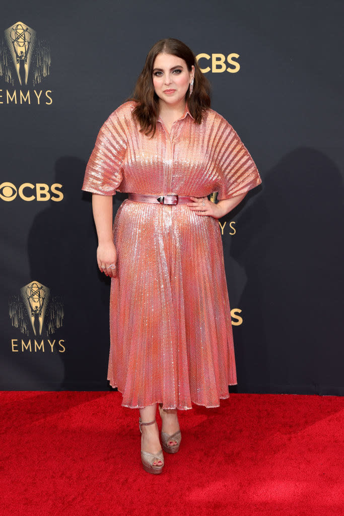 Beanie Feldstein on the red carpet in a calf-length coral dress