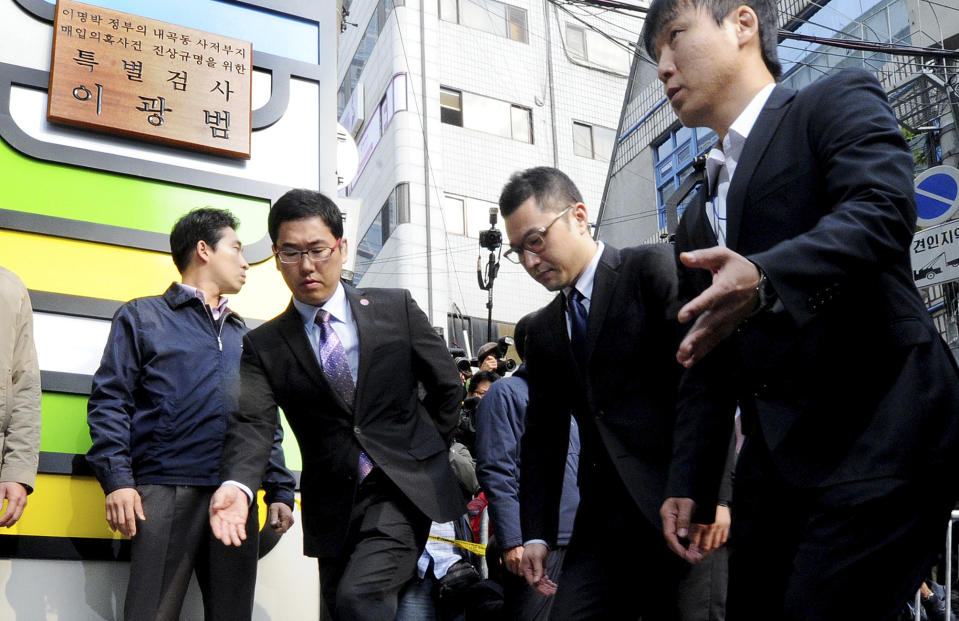 Lee Si-hyung, the son of South Korean President Lee Myung-bak, is guided upon his arrival for questioning in front of the special prosecutors office in Seoul, South Korea, Thursday, Oct. 25, 2012. South Korean special prosecutors have summoned President Lee's son in part of their investigation into alleged irregularities in funding the leader’s retirement home. (AP Photo/Kim Ju-sung, Yonhap) KOREA OUT