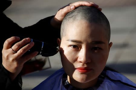 Li Wenzu, the wife of prominent Chinese rights lawyer Wang Quanzhang, has her head shaved in protest over the government's treatment of her husband in Beijing, China, December 17, 2018. REUTERS/Thomas Peter