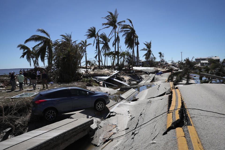 A car teeters on a buckled roadway in Matlacha, Fla.