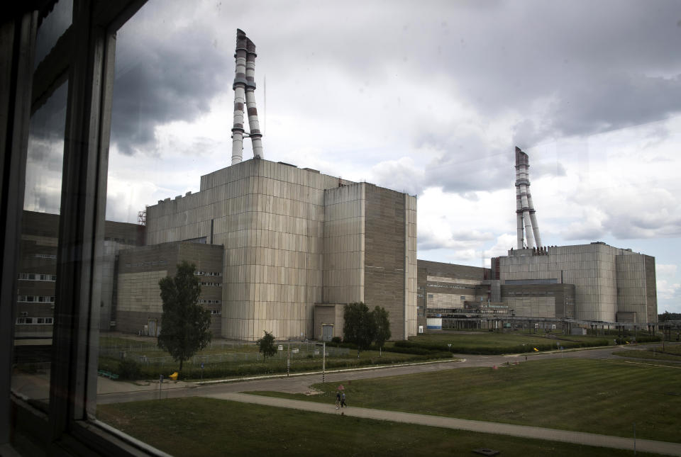 In this photo taken on Tuesday, July 16, 2019, workers walk past a part of the Ignalina nuclear power plant (NPP) in Visaginas some 160km (100 miles) northeast of the capital Vilnius, Lithuania. The HBO TV series “Chernobyl” featuring Soviet era nuclear nightmares is drawing tourists to the atomic filming locations in Lithuania. (AP Photo/Mindaugas Kulbis)