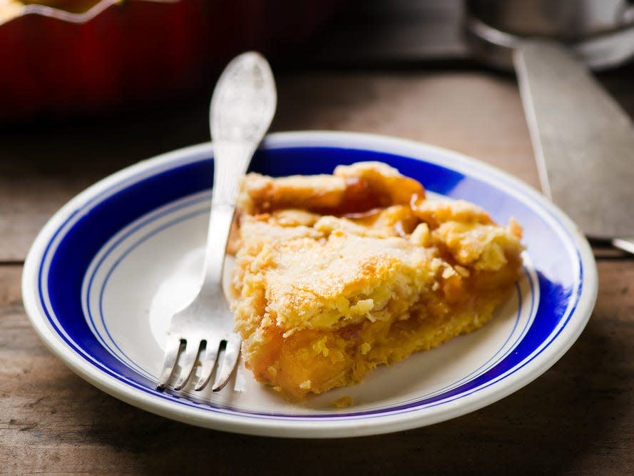 Peach pie on a blue and white plate with a fork