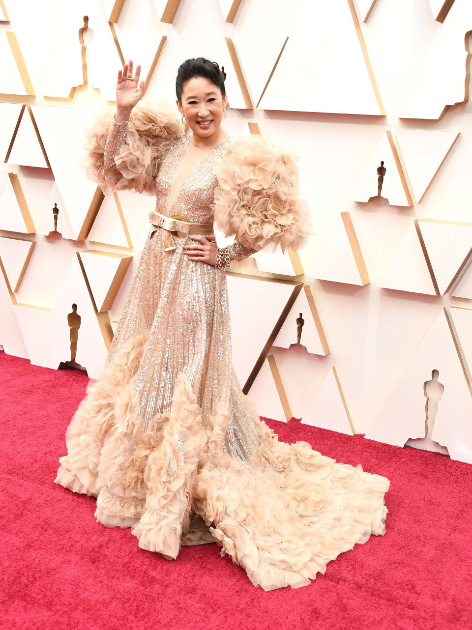 Sandra wearing a long gold gown with beads