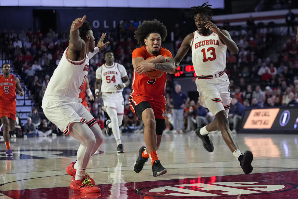 Auburn guard Tre Donaldson (3) protects the ball as he drives between Georgia's Justin Hill (11) and Dylan James (13) during the first half of an NCAA college basketball game Saturday, Feb. 24, 2024, in Athens, Ga. (AP Photo/John Bazemore)