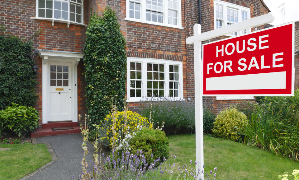 For sale sign outside a house in an affluent suburb of London