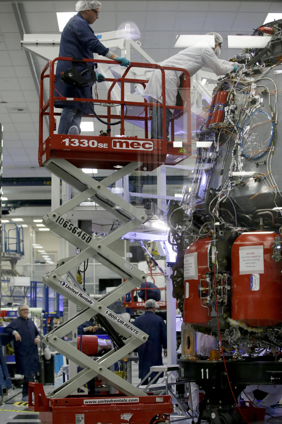 SpaceX employees work on the Crew Dragon spacecraft that will take astronauts to and from the International Space Station, from American soil, as part of the agency's commercial crew Program, in Hawthorne, Calif., Thursday, Oct. 10, 2019. (AP Photo/Alex Gallardo)