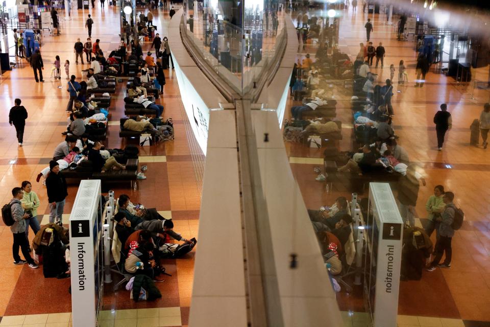 Passengers wait in Terminal 2 of Haneda International Airport, as operations are suspended due to a Japan Airlines' A350 airplane and a Coast Guard aircraft collision (REUTERS)