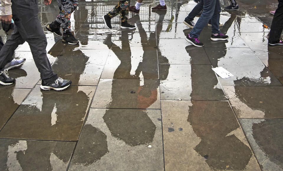 Members of the public  walk through heavy rain in Westminster, London (Picture: PA)