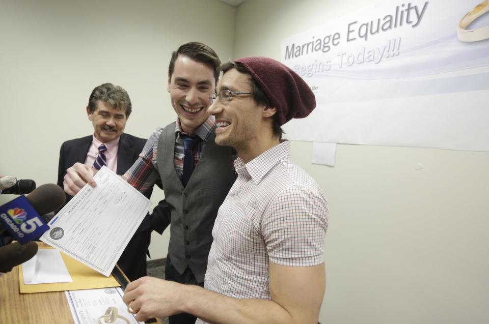 CORRECTS SPELLING TO WILK IN SECOND REFERENCE INSTEAD OF WILL - Charlie Gurion, center, and David Wilk hold up their marriage license as Cook County Clerk David Orr, left looks on Friday, Feb. 21, 2014, in Chicago. Same-sex couples in Illinois' largest county began receiving marriage licenses immediately after a federal judge's ruling Friday that some attorneys said could give county clerks statewide justification to also issue the documents right away. Illinois approved same-sex marriage last year; the new law takes effect June 1. However, U.S. District Judge Sharon Johnson Coleman ruled Friday that same-sex marriages can begin now in Cook County, where Chicago is located. Gurion and Wilk were the first couple to show up to get a license after the judge made her ruling. (AP Photo/M. Spencer Green)